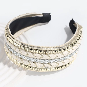 Detailed close-up of braided headband featuring gold studs and sparkling rhinestones