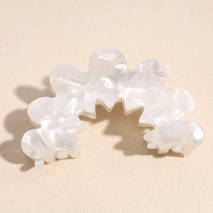 Detailed macro view of pearlescent acetate hair claw with elegant marble texture