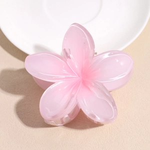 Macro shot of a pink translucent flower hair claw clip with a glossy resin finish