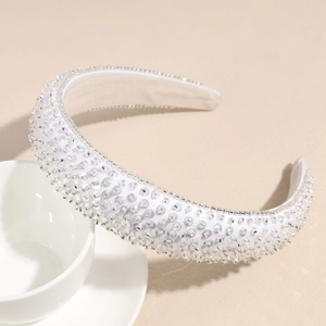 Vue détaillée d'un serre-tête blanc rembourré avec paillettes argentées et perles