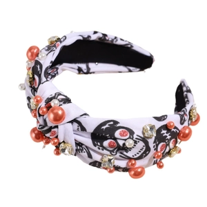 Halloween headband with skull pattern, orange pearls and rhinestones on white fabric