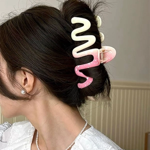 Detail showing the wavy gradient pink large shark hair clip on a model's updo hairstyle
