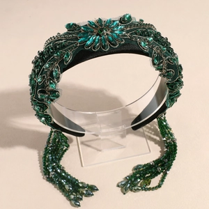 Détail d'un serre-tête baroque avec cristaux émeraude et pompons perlés scintillants
