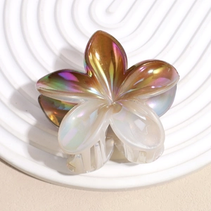 Macro shot of a floral hair claw clip featuring pearlescent gradient petals and a spring clamp