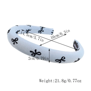 Detail view of a padded light blue headband with bow patterns and size measurements