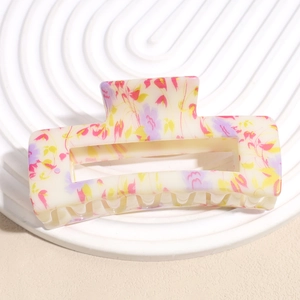 Detailed view of large cream floral hair claw clip with colorful flower patterns