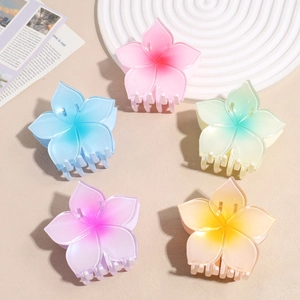 Detailed macro view of large five-petal flower hair claws in assorted gradient pastel colors