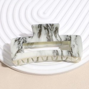 Detail of large acetate hair claw clip featuring black and white marble ink texture