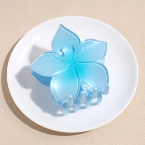 Macro detail of a light blue five-petal flower hair claw clip with a matte pearl finish