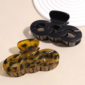 Minimalist chain link hair claws in black and tortoiseshell finish on a tray