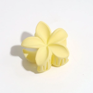 Gros plan détaillé d'une pince à cheveux fleur jaune mat avec des dents imbriquées robustes