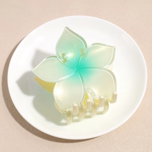 Macro detail of gradient green pearl finish flower hair claw clip with multi-tooth grip