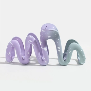 Detail of large wave-shaped shark hair clip with purple and green gradient matte finish