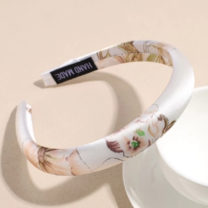 Detailed view of handmade satin floral headband with pink blossoms and inner black label