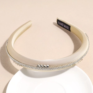 Détail de serre-tête rembourré en satin champagne fait main avec strass et bordure en zircon
