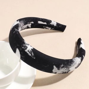 Detailed macro view of black sponge headband with artistic white marble ink patterns
