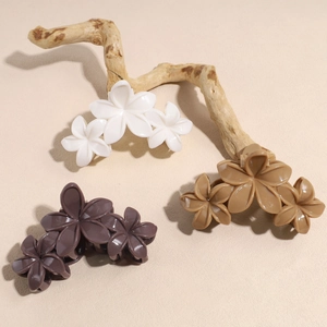Pinces à cheveux élégantes en forme de fleurs crème et café sur une branche naturelle