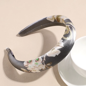 Detail of grey satin headband with white floral print and fine stitching craftsmanship