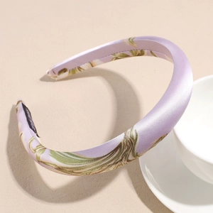 Detail of lavender satin headband with green leaf print and thick padded design