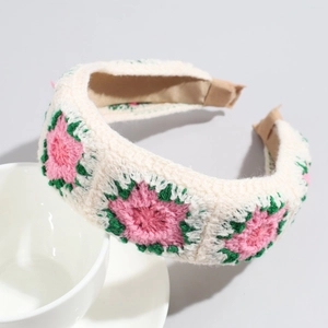 Dettaglio del cerchietto all'uncinetto fatto a mano con ricami floreali rosa e trama