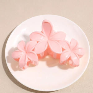 Détail d'une pince à cheveux à fleurs roses sur une assiette pour coiffure élégante