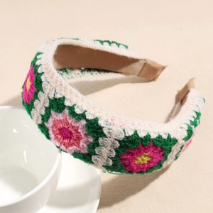 Dettaglio della fascia lavorata a maglia con fiori rosa e gialli su trama bianca