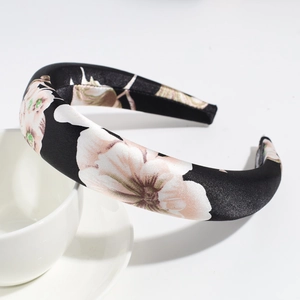 Detail of elegant satin sponge headband with large floral print on black fabric