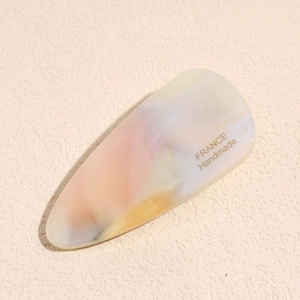 Close-up of handmade marble-textured acetate hair clip with gold lettering