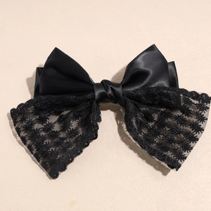 Close-up of the elegant black satin and lace double-layered bow hair clip details