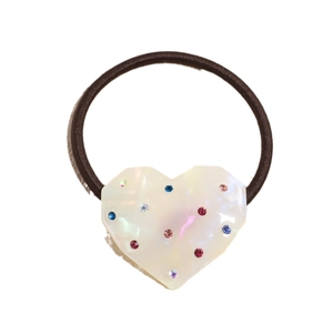 Elastic hair tie featuring a pearlescent heart charm with multi-colored crystals