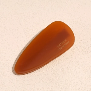Detail view of amber acetate hair clip with golden France Handmade engraving