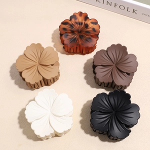 Matte and glossy flower hair claws in tortoiseshell, beige, and brown color variations