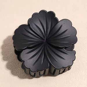 Detailed macro shot of the black matte floral hair claw clip with 3D petal textures