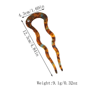 Close-up of U-shaped tortoise hair pin with wavy fork and sparkling rhinestone detail