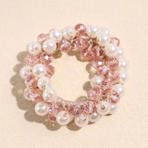 Détail d'un chouchou élastique avec des perles blanches et des perles de cristal roses