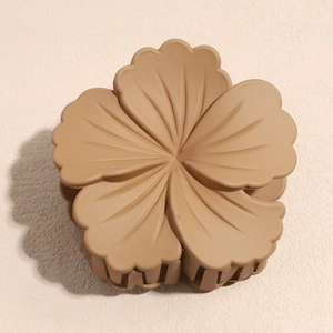 Detail of matte khaki flower hair claw clip with realistic petal texture and strong grip