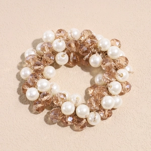 Détail d'un élastique à cheveux avec perles blanches et perles en cristal de champagne