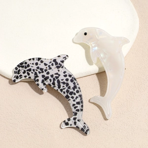 Leopard pattern and pearlescent acetate dolphin hair clips set on stone background