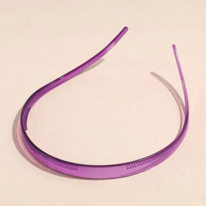 Detail van paarse doorschijnende hoofdband met antislip tanden op getextureerd vlak