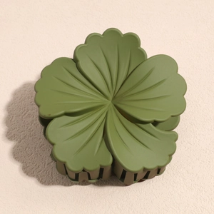 Macro detail of olive green matte flower hair claw clip with textured petals and sturdy teeth