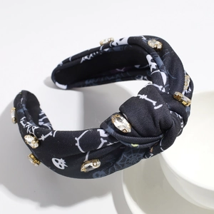 Macro detail of Halloween headband with skull print and gold-clawed rhinestones