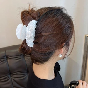 Elegante pinza per capelli in acetato bianco con strass su capelli castano scuro
