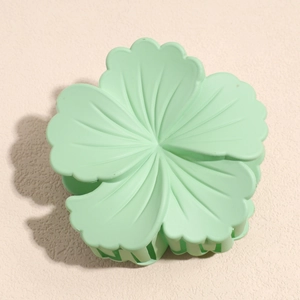 Detail of mint green matte flower hair claw clip with layered petal texture and sturdy teeth