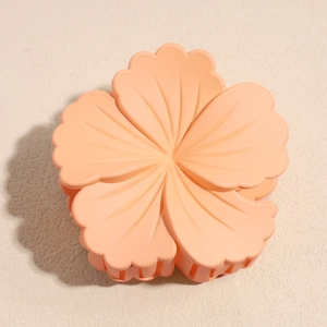 Detailed top view of matte salmon pink flower claw clip with natural petal textures
