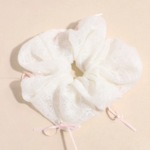 Detail of oversized lace scrunchie with pink satin bows and white pearl decoration
