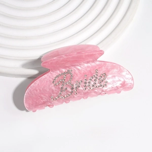 Dettaglio molletta per capelli in acetato rosa con scritta Bride in strass