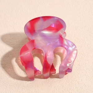 Macro detail of pink and purple acetate hair claw with marble texture and pearly luster