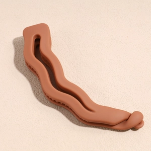 Détail de la pince banane ondulée caramel avec une finition mate et une prise dentelée