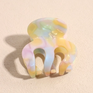 Macro view of colorful acetate hair claw with marble texture and polished glossy finish