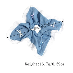 Detail view of denim scrunchie with lace edge and colorful bows showing 25.5cm diameter